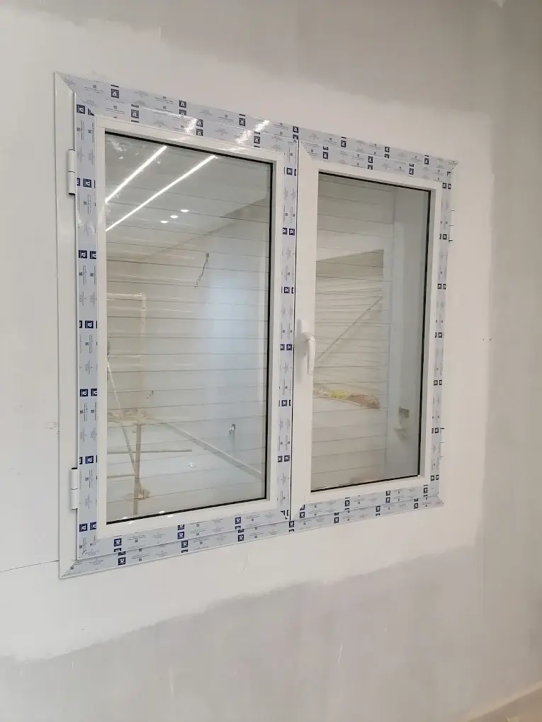 Fenêtre battante en aluminium blanc à deux vantaux, encore protégée par son film de pose