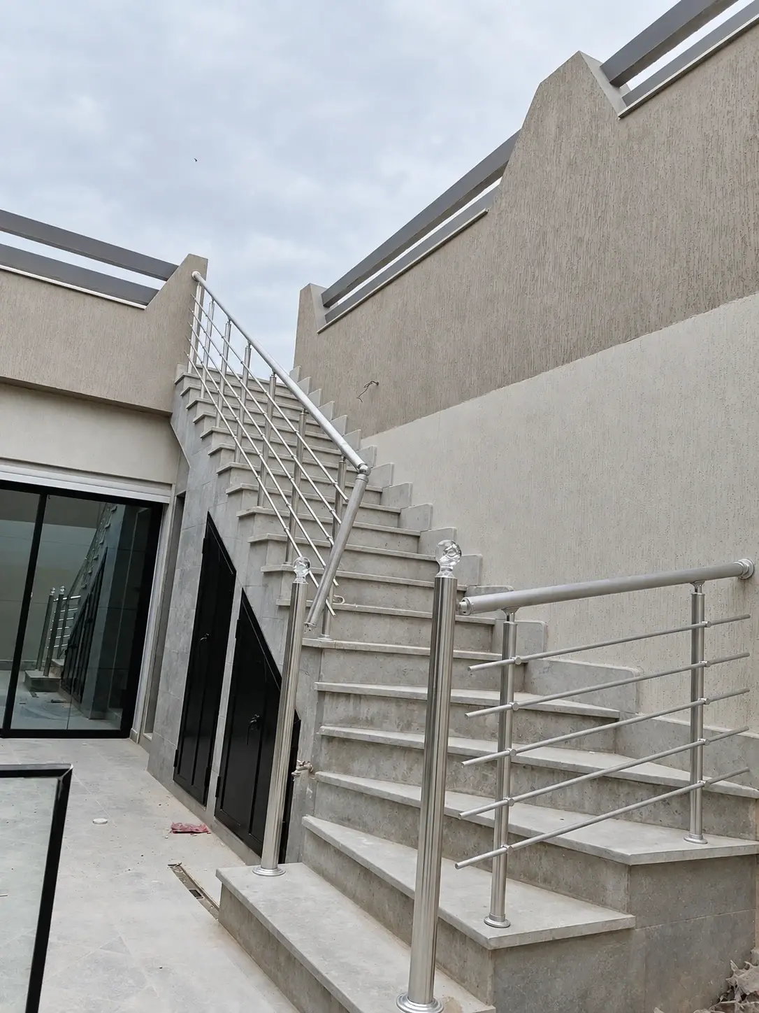 Garde-corps d'escalier extérieur en aluminium finition argent, avec main courante ronde et lisses horizontales
