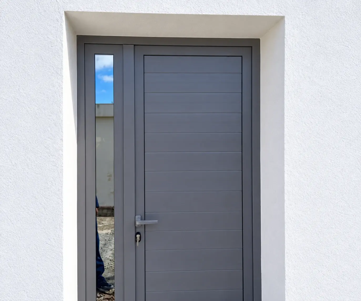 Porte d'entrée en aluminium gris à panneau rainuré horizontal, avec un vitrage latéral fixe